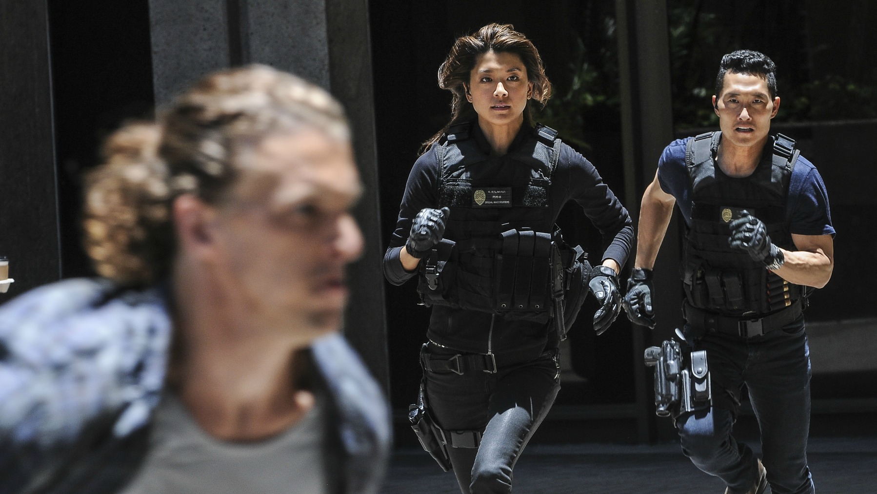 Chin Ho and Kono race after a suspect.
